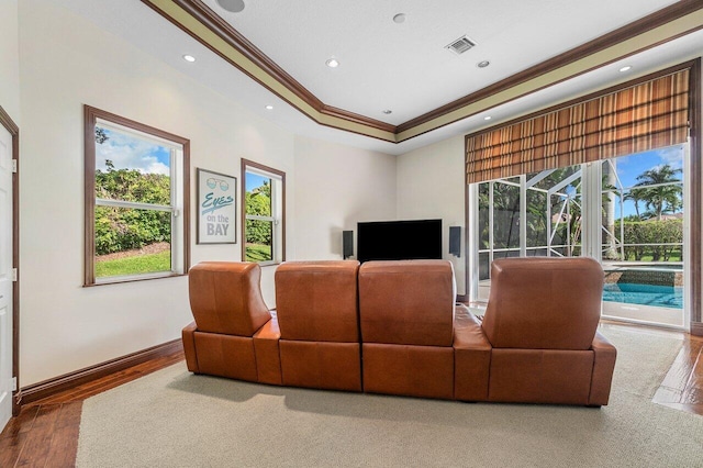 living room featuring a wealth of natural light, hardwood / wood-style flooring, crown molding, and a tray ceiling