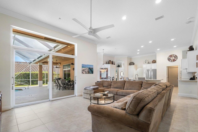 living room with ceiling fan, a healthy amount of sunlight, light tile patterned floors, and crown molding