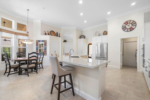 kitchen featuring white cabinets, sink, a spacious island, and decorative light fixtures