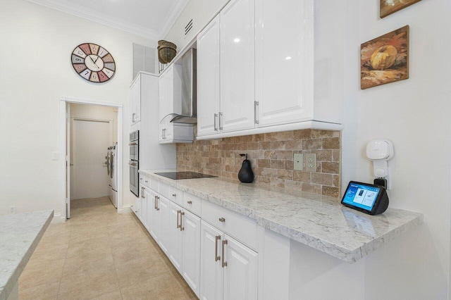 kitchen featuring white cabinetry, light stone counters, wall chimney exhaust hood, light tile patterned floors, and double oven