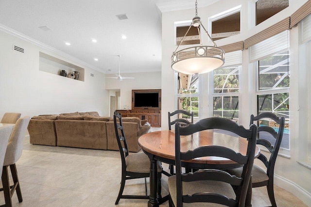 tiled dining space featuring ornamental molding and ceiling fan