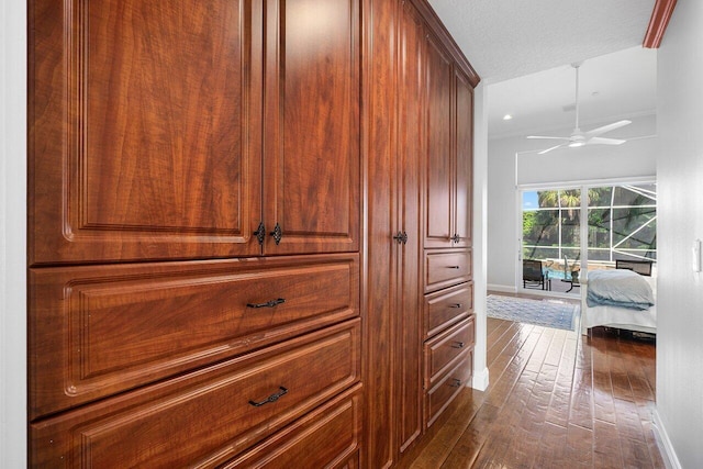 corridor with a textured ceiling, dark hardwood / wood-style floors, and crown molding