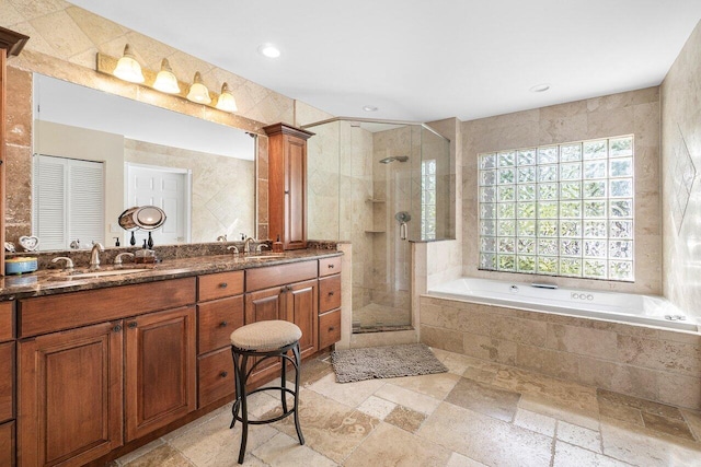 bathroom featuring tile walls, independent shower and bath, and vanity