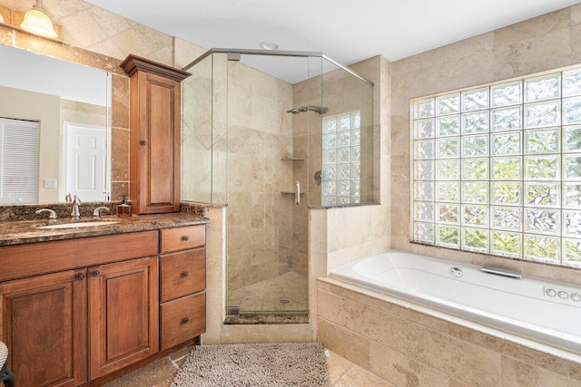 bathroom featuring vanity, a healthy amount of sunlight, and independent shower and bath