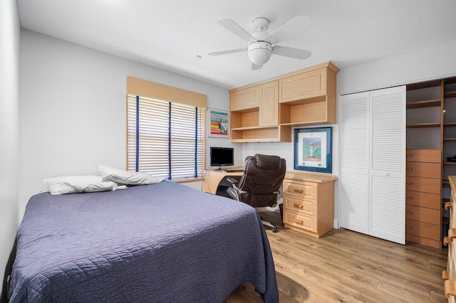 bedroom featuring a textured ceiling, light hardwood / wood-style floors, ceiling fan, and a closet