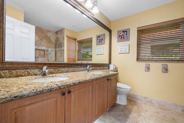 bathroom with a shower with shower door, vanity, tile patterned floors, and toilet