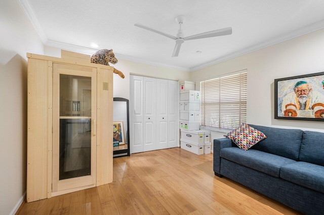 living area featuring light hardwood / wood-style floors, ceiling fan, and crown molding