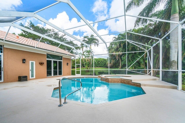 view of swimming pool featuring glass enclosure, a patio, and an in ground hot tub