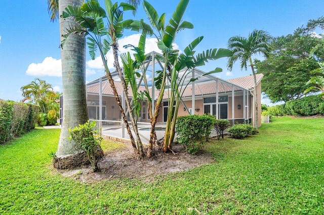 view of side of property with a yard and a lanai