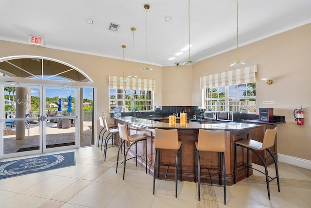 kitchen featuring hanging light fixtures, a kitchen breakfast bar, kitchen peninsula, and decorative backsplash