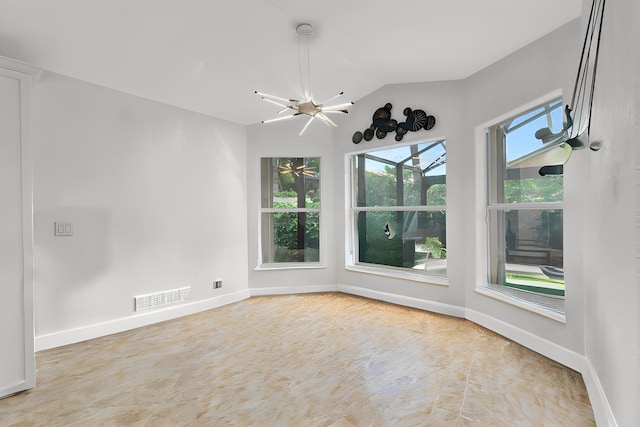 empty room featuring an inviting chandelier and vaulted ceiling