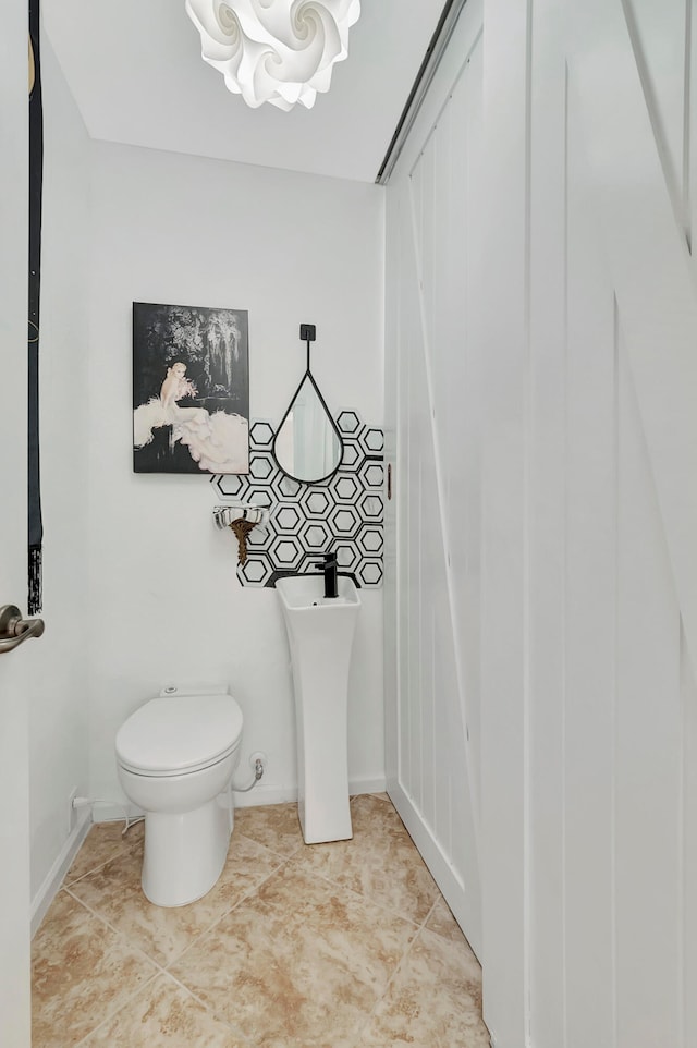 bathroom with sink, toilet, and tile patterned flooring