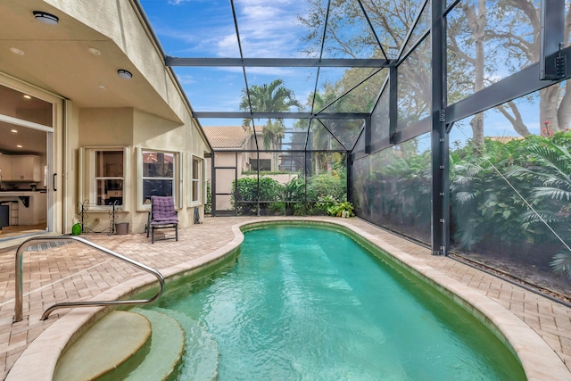 view of pool with a patio area and a lanai