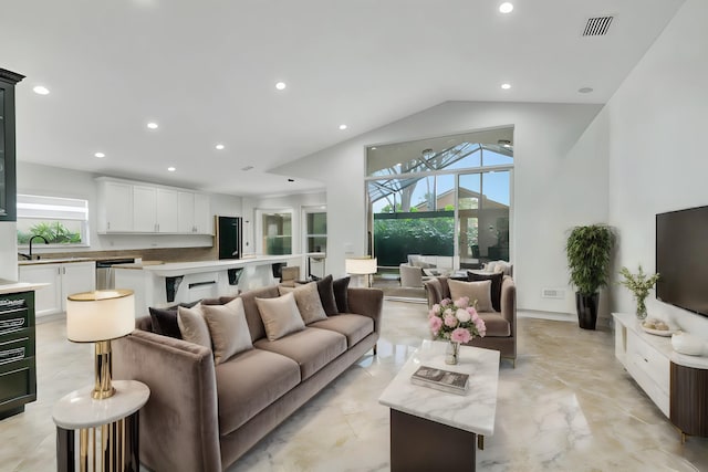 living room featuring lofted ceiling, sink, and a wealth of natural light