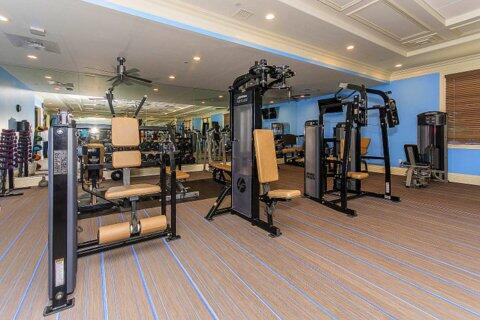 workout area with crown molding, coffered ceiling, and ceiling fan