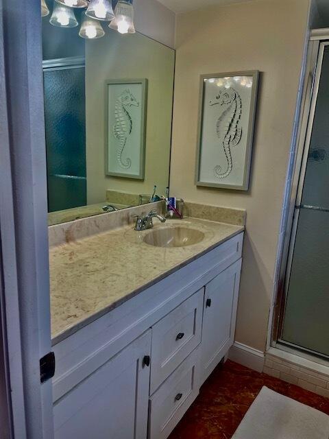 bathroom with a shower with door and vanity