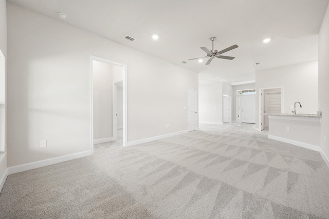 interior space featuring light carpet, sink, and ceiling fan