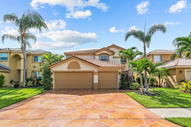 mediterranean / spanish house with a front yard and a garage