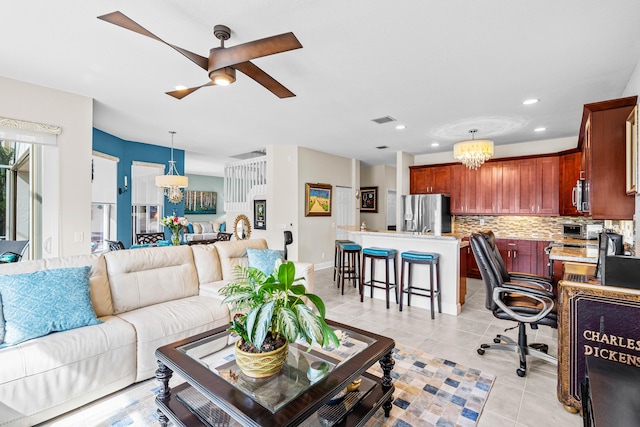 tiled living room featuring ceiling fan with notable chandelier