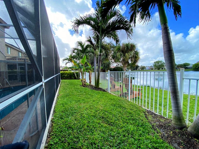 view of yard featuring a lanai and a water view