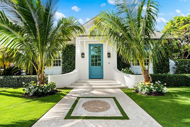 entrance to property featuring a lawn