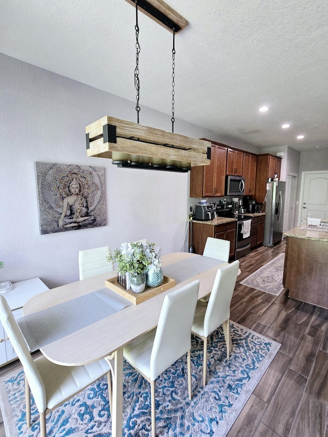 dining space featuring a textured ceiling and dark wood-type flooring