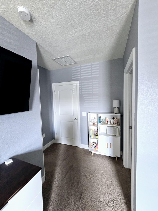 interior space featuring a textured ceiling and carpet floors