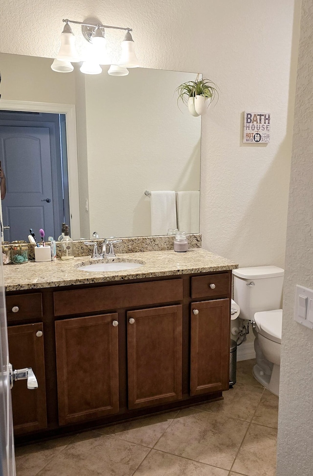 bathroom featuring vanity, toilet, and tile patterned floors