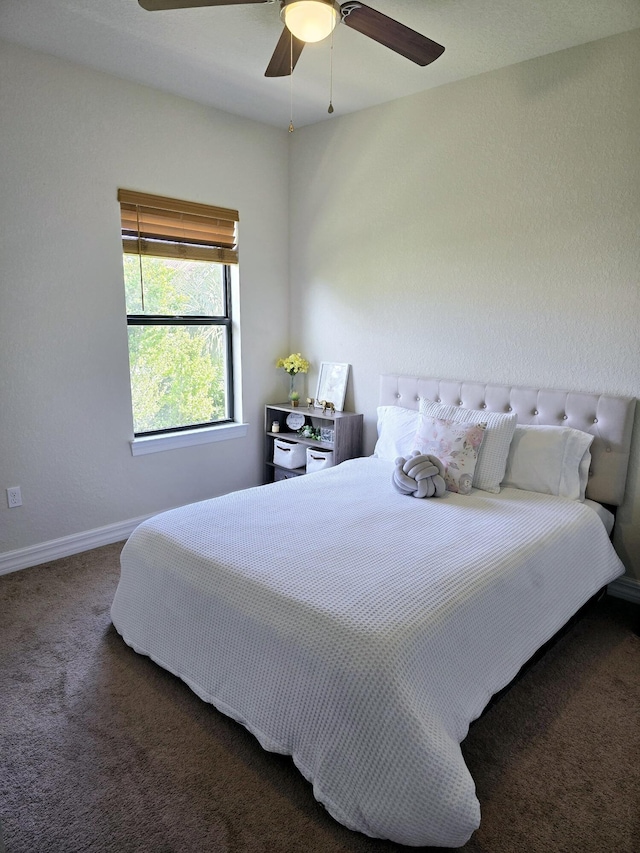 bedroom with ceiling fan and dark carpet