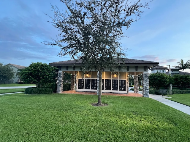 back house at dusk with a lawn