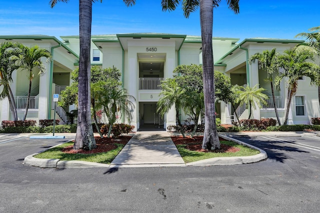 view of property with stucco siding and uncovered parking