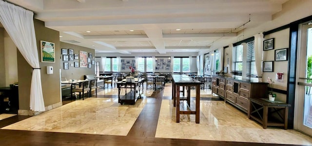 dining space featuring light hardwood / wood-style flooring, beam ceiling, coffered ceiling, and plenty of natural light