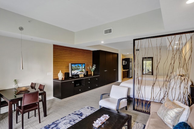 living room featuring light carpet and a raised ceiling