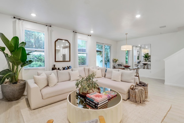 living room with a chandelier and light wood-type flooring