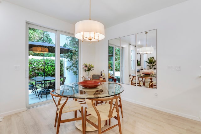 dining area with a chandelier, light hardwood / wood-style floors, and a healthy amount of sunlight