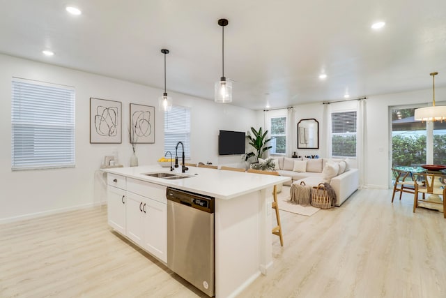 kitchen with white cabinetry, sink, stainless steel dishwasher, and a kitchen island with sink