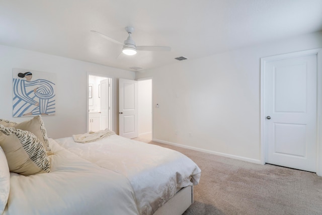 bedroom with ceiling fan, ensuite bath, and light colored carpet