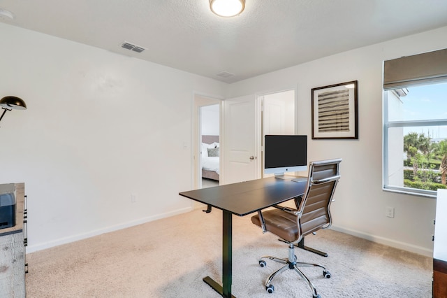 home office featuring carpet flooring and a textured ceiling