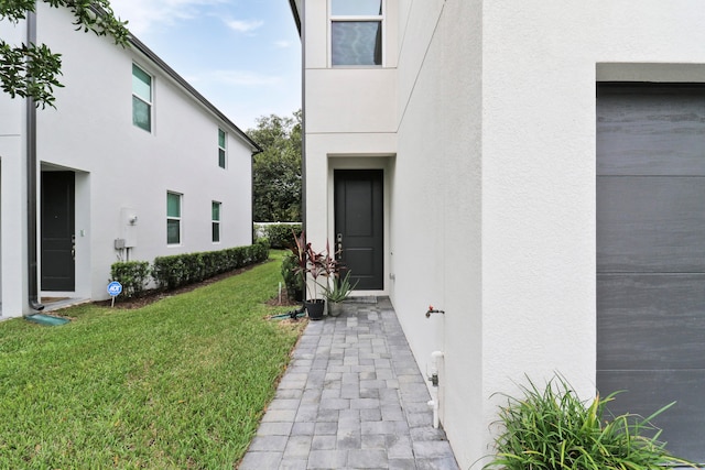 view of exterior entry with a lawn