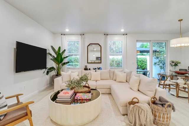 living room featuring a healthy amount of sunlight, an inviting chandelier, and light colored carpet