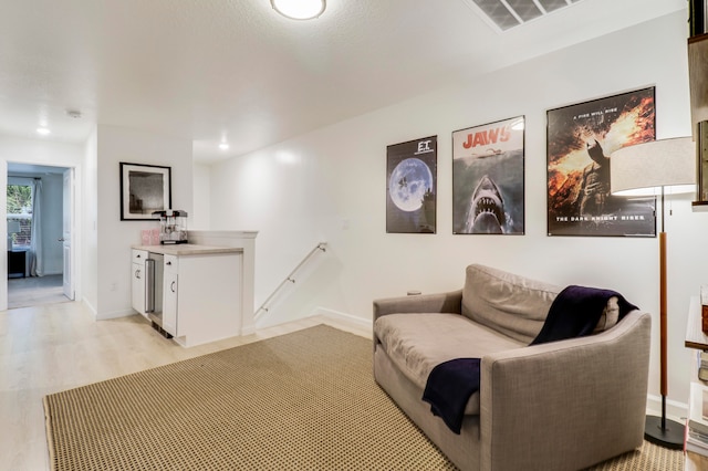 sitting room with light hardwood / wood-style flooring and beverage cooler