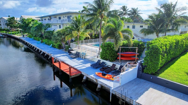 dock area featuring a water view and a community pool