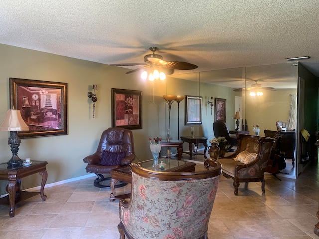 sitting room featuring light tile patterned floors, a textured ceiling, and ceiling fan