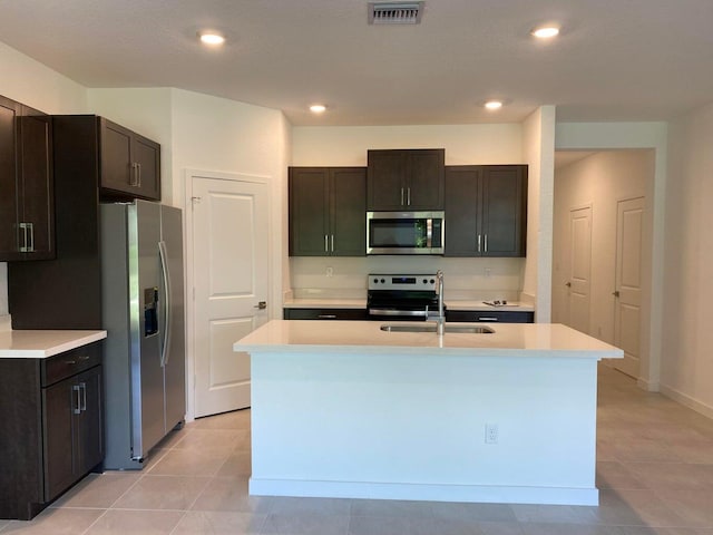 kitchen featuring dark brown cabinets, an island with sink, appliances with stainless steel finishes, and sink