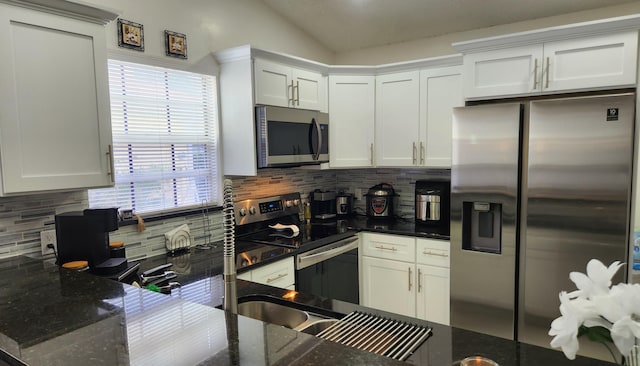 kitchen with appliances with stainless steel finishes, dark stone counters, decorative backsplash, and white cabinets