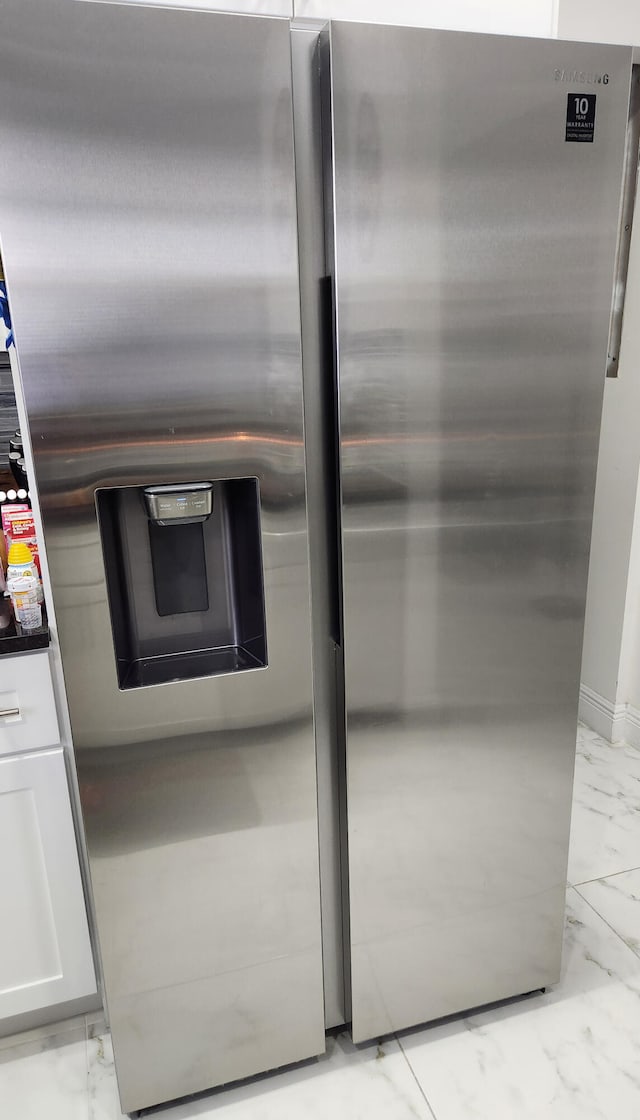 interior details with stainless steel fridge with ice dispenser and white cabinetry