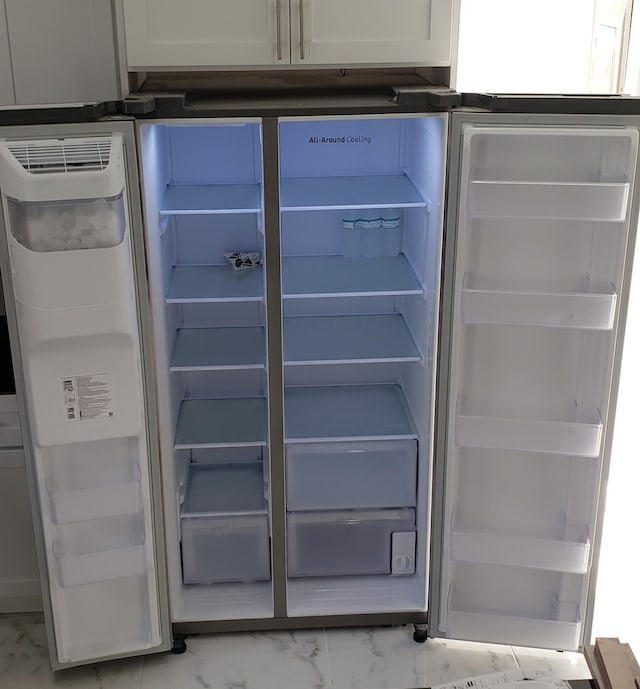 room details featuring white cabinetry and refrigerator