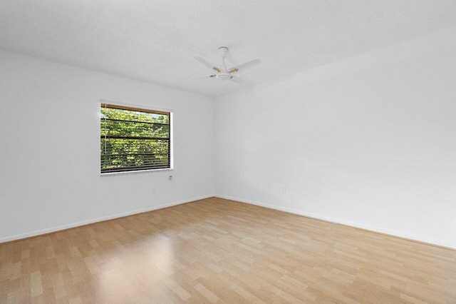 empty room featuring ceiling fan, a textured ceiling, and light hardwood / wood-style flooring