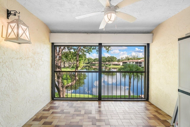 empty room featuring a water view and ceiling fan