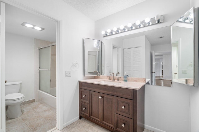 full bathroom with vanity, a textured ceiling, bath / shower combo with glass door, toilet, and tile patterned floors